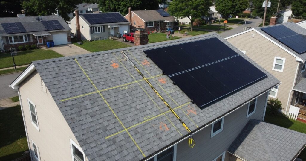 Aerial view of a house roof with partial solar array and chalk layout marks for system sizing